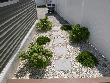 This is an image of a tile patio with orange patio furniture. LandTech Landscaping specializes in patio installation similar to the one shown here.